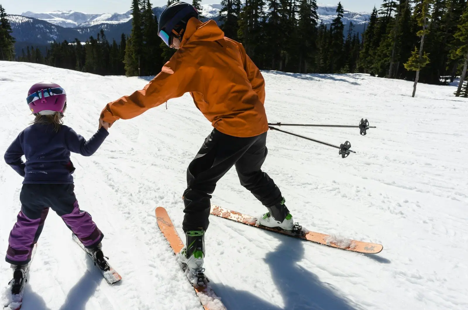 a woman teaching a child how to ski