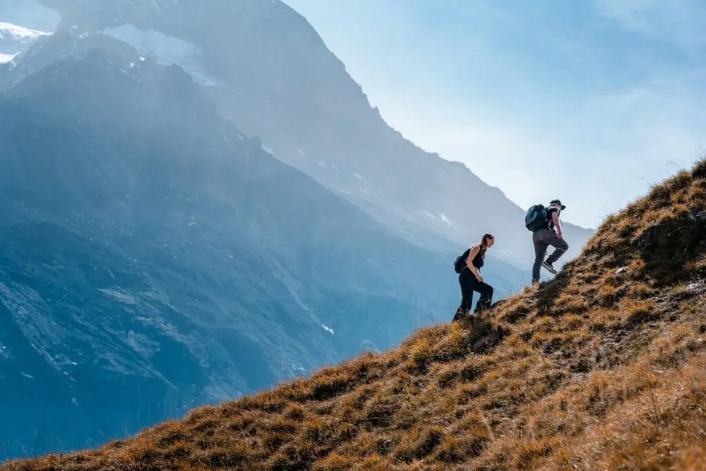 Two hikers are ascending a mountain