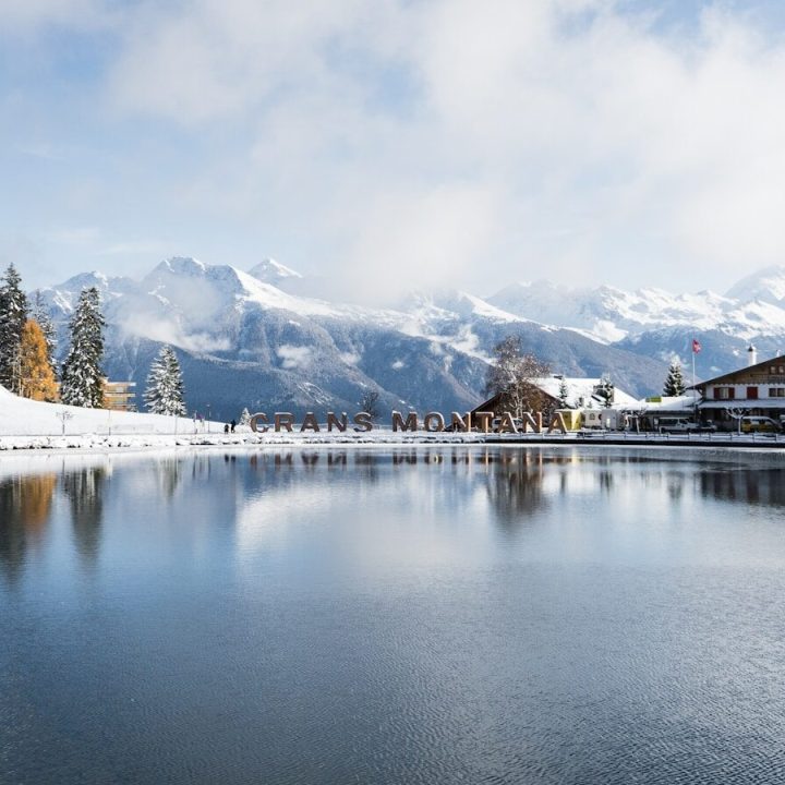 lake near trees and mountains under white clouds and blue sky during daytime